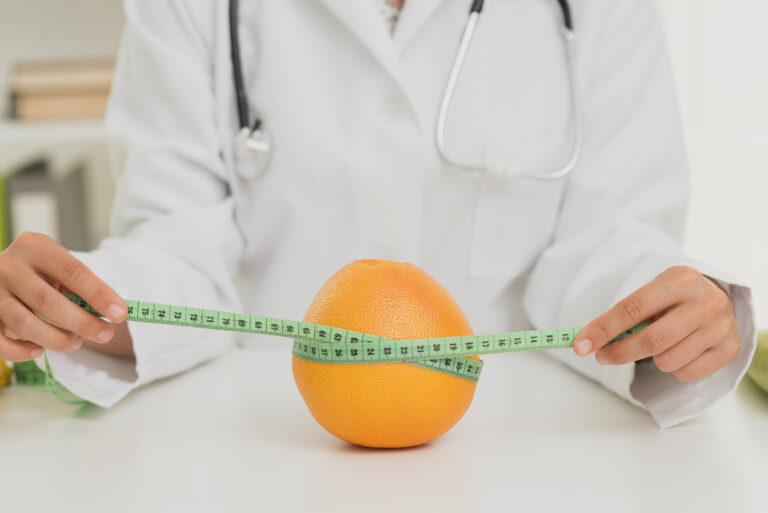 close up nutritionist measuring orange