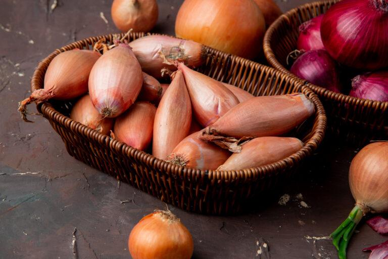 close up view basket full onions maroon background