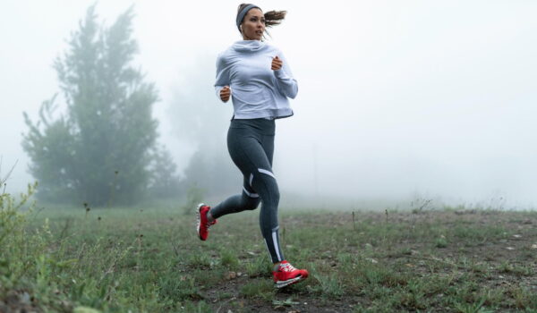 determined female runner jogging through misty filed morning copy space