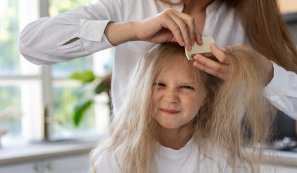 front view woman helping girl with lices
