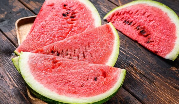 heap fresh red sliced watermelon dark wooden background top view