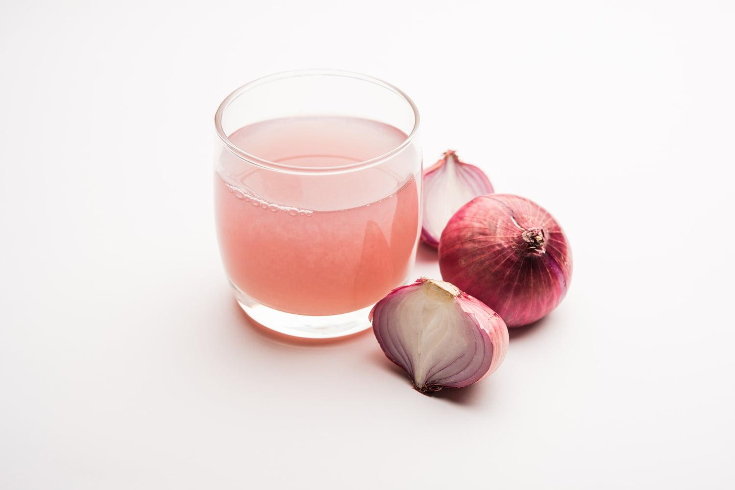 medicinal onion juice syrup glass with raw onions selective focus
