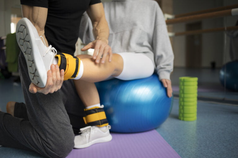 patient doing physical rehabilitation helped by therapists