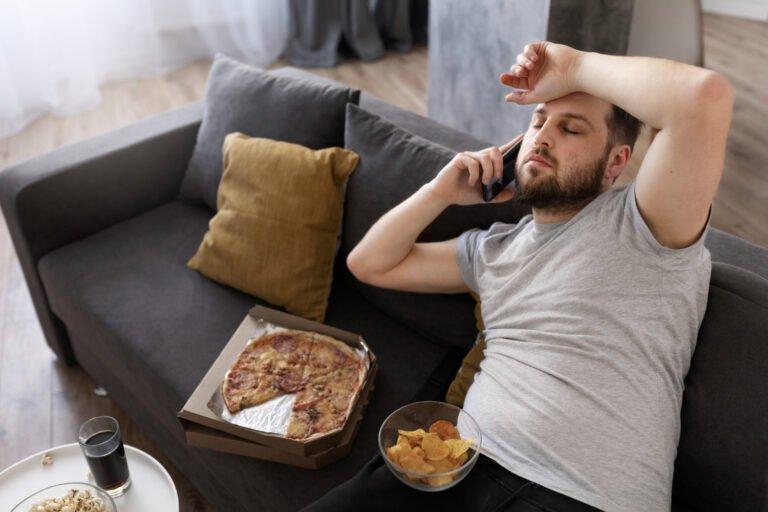 young man eating junk food home sofa